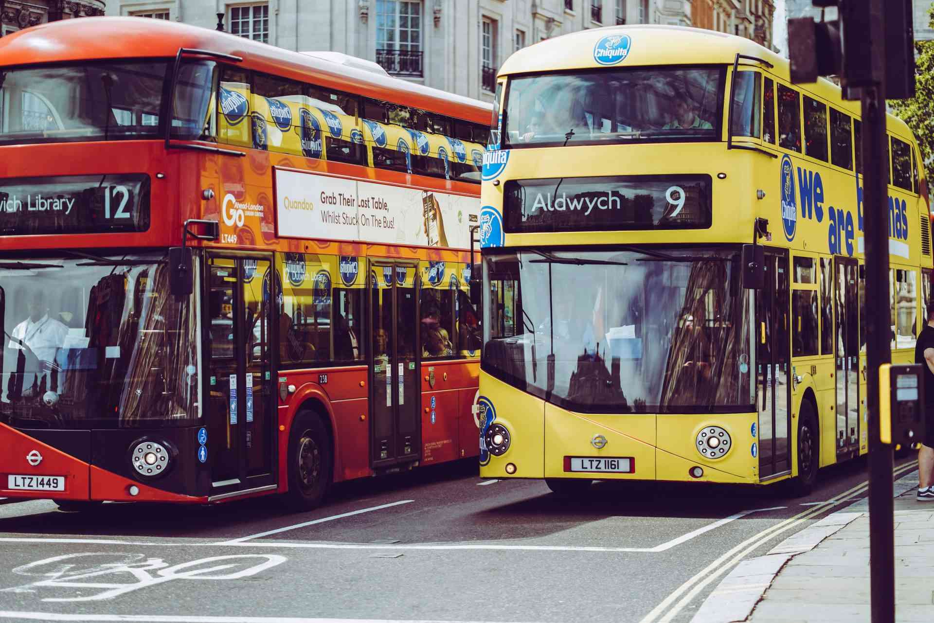 two yellow and red double-decker buses on gray concrete road